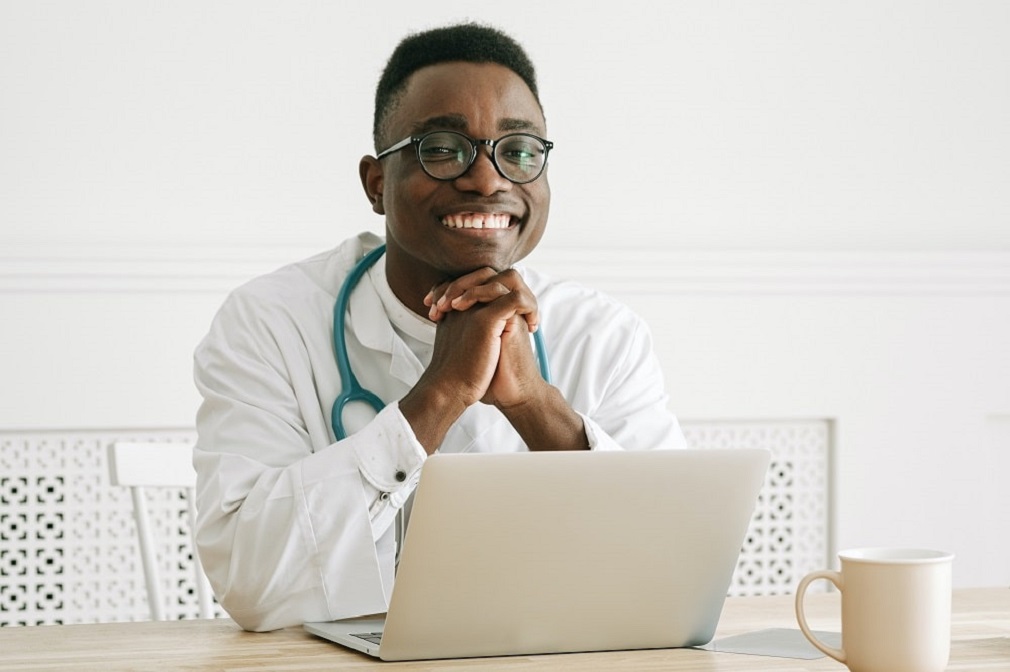 A smiling doctor using employee scheduling software for hospitals